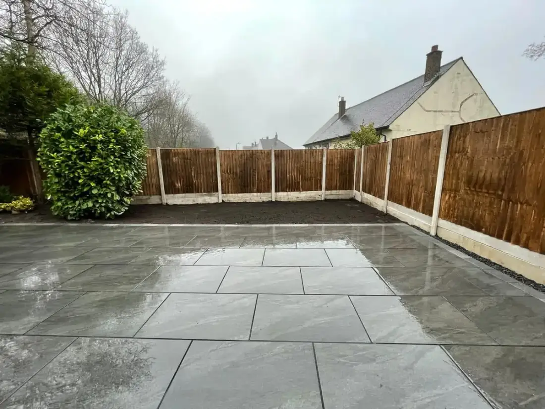 Large grey porcelain patio with new timber fencing on concrete posts