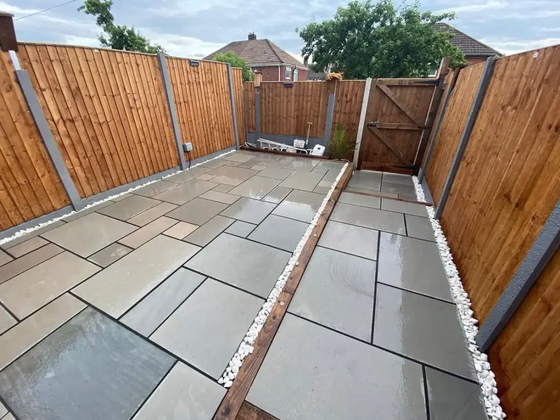 New timber panel fencing on concrete posts with a matching gate around a grey patio