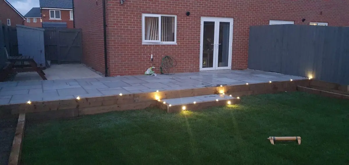 Raised patio with lights set into the step, lit up at dusk