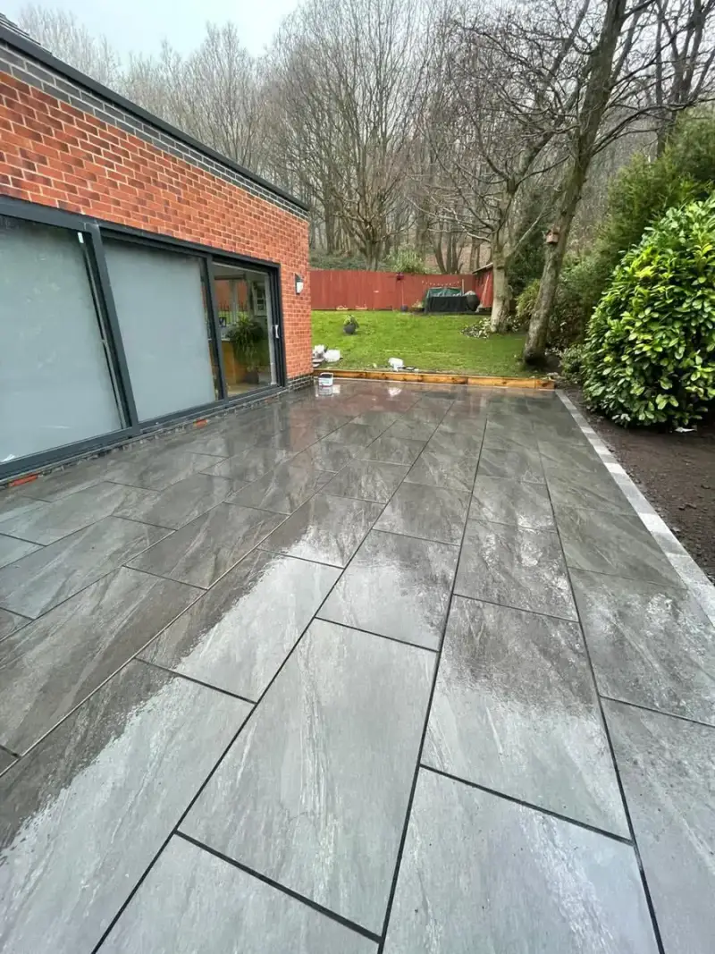 Grey porcelain patio along a flat-roof extension with sliding doors