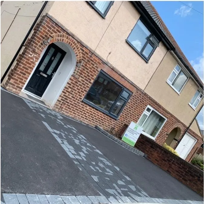 Grey paved front path leading to a front door