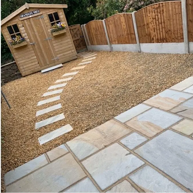 Sandstone path and gravel area in front of a timber summer house