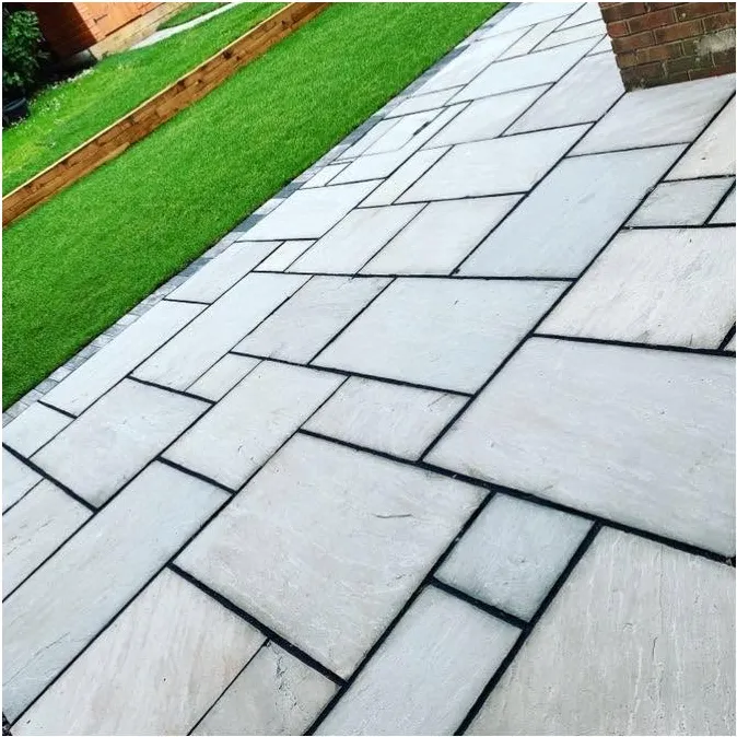 Grey slab patio meeting an artificial lawn